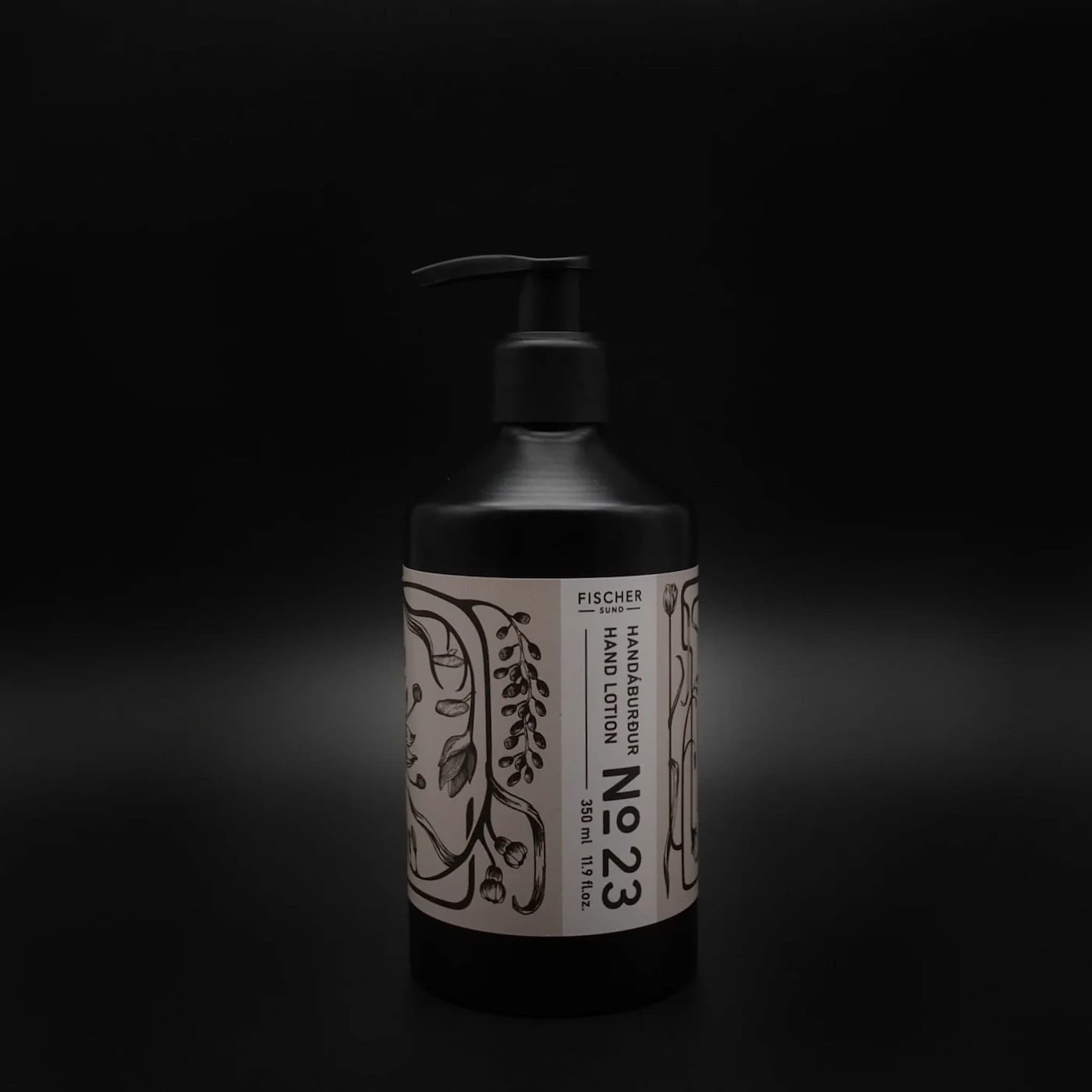 Black bottle of Fischersund 23 Hand Lotion with a white label on a dark background