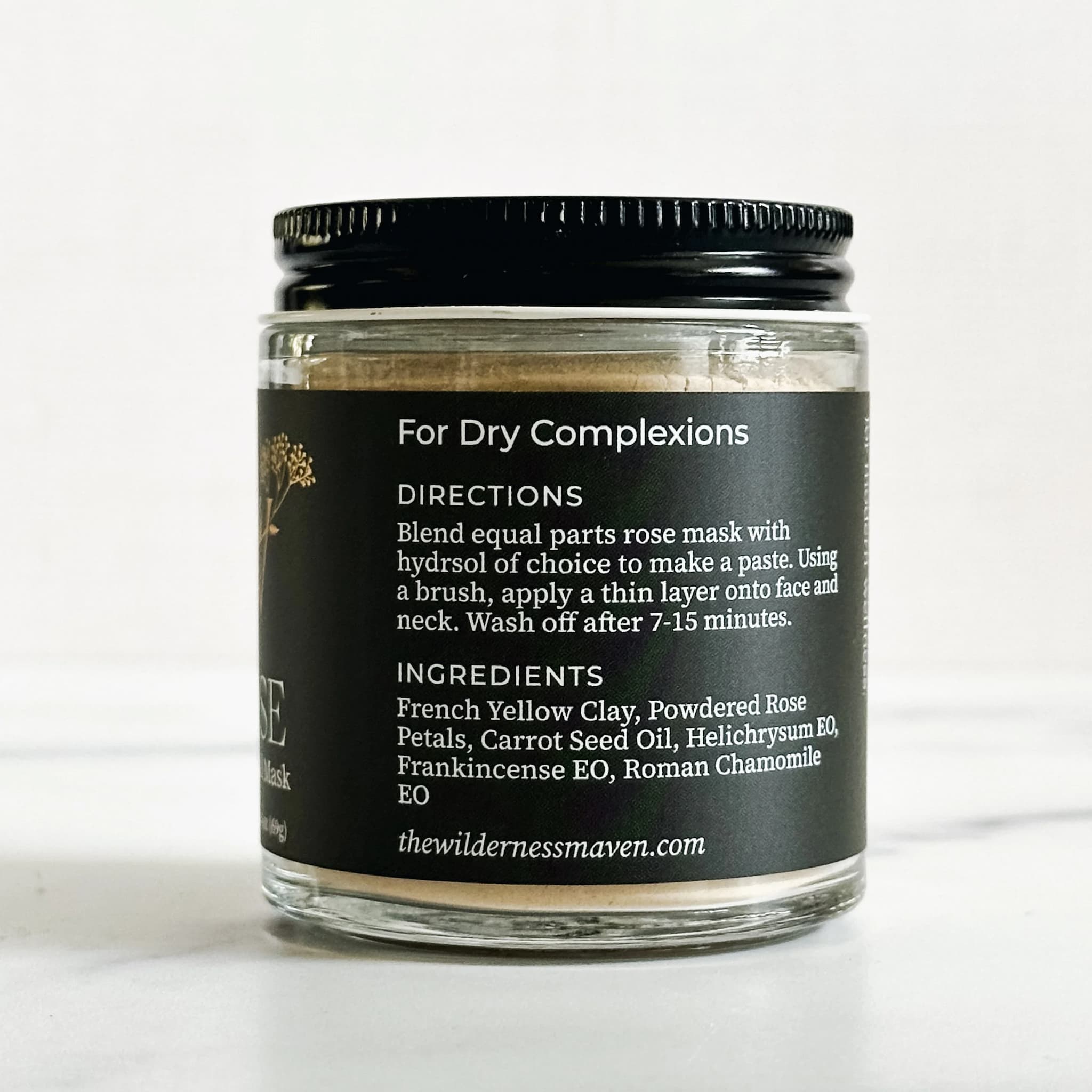 Glass jar with black lid and label on a white background