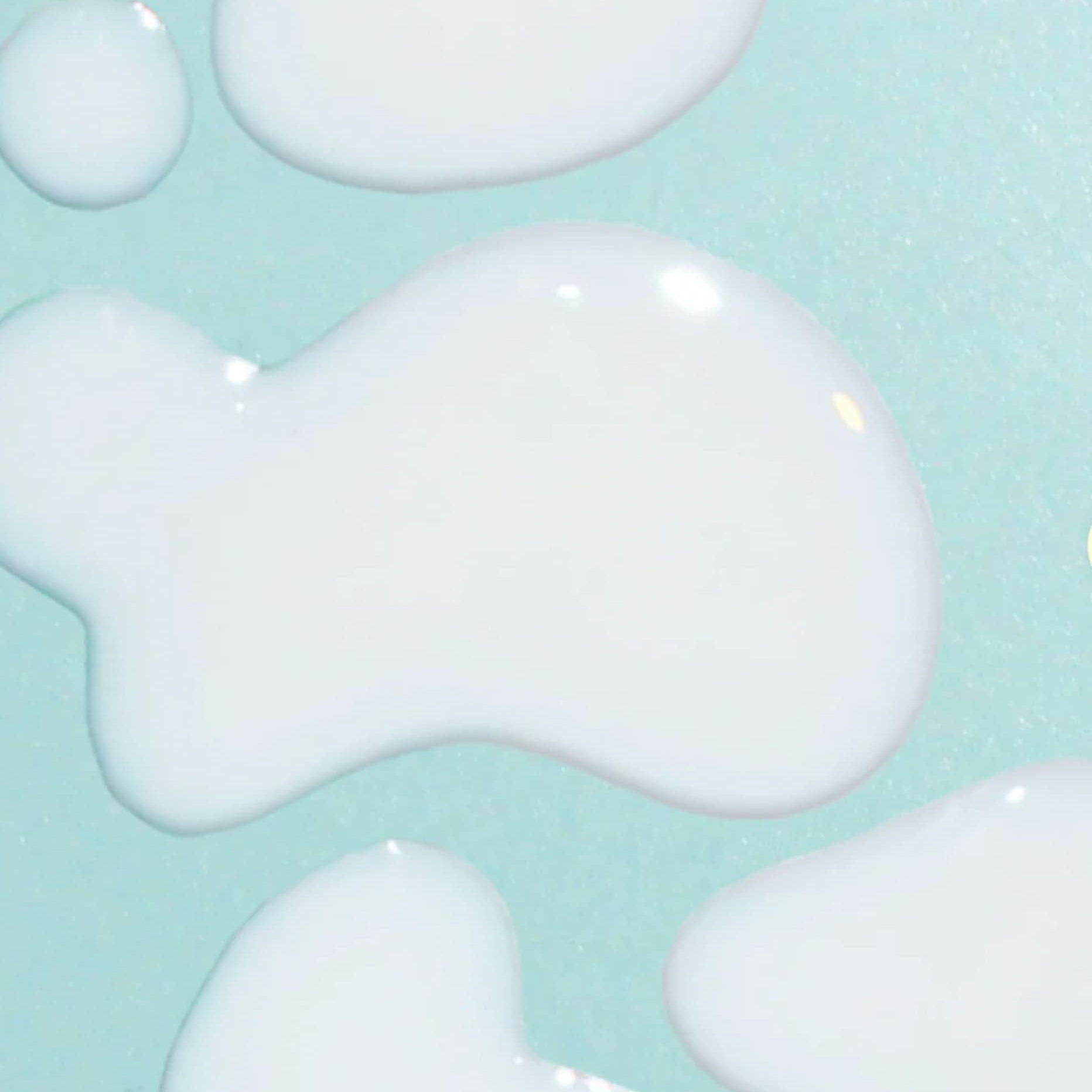 SPF 30 sunscreen serum by bask, in droplets on a blue background.