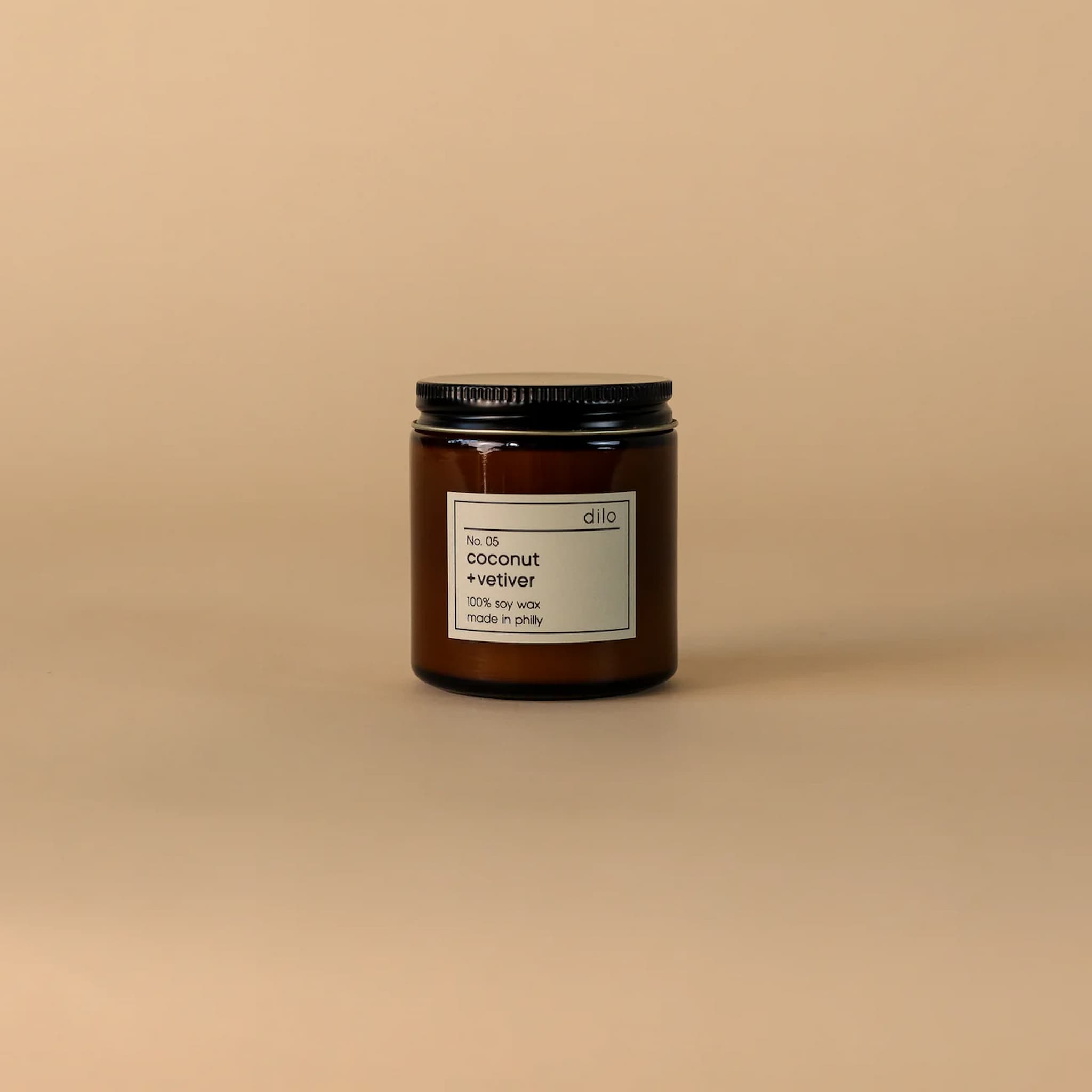 Candle jar with a label on a beige background