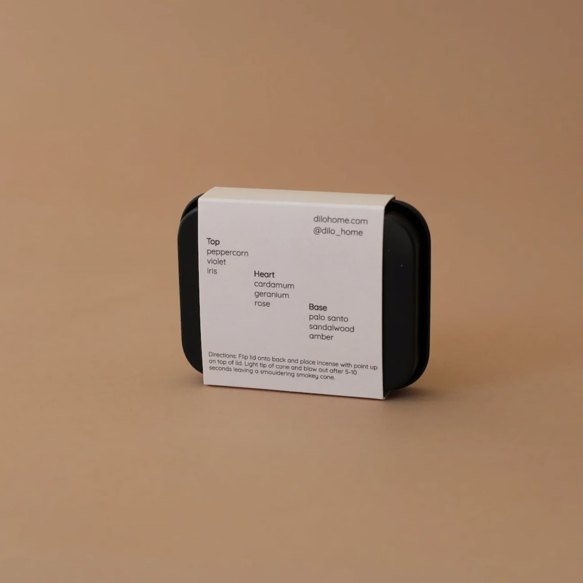 Small black container with a white label on a brown background