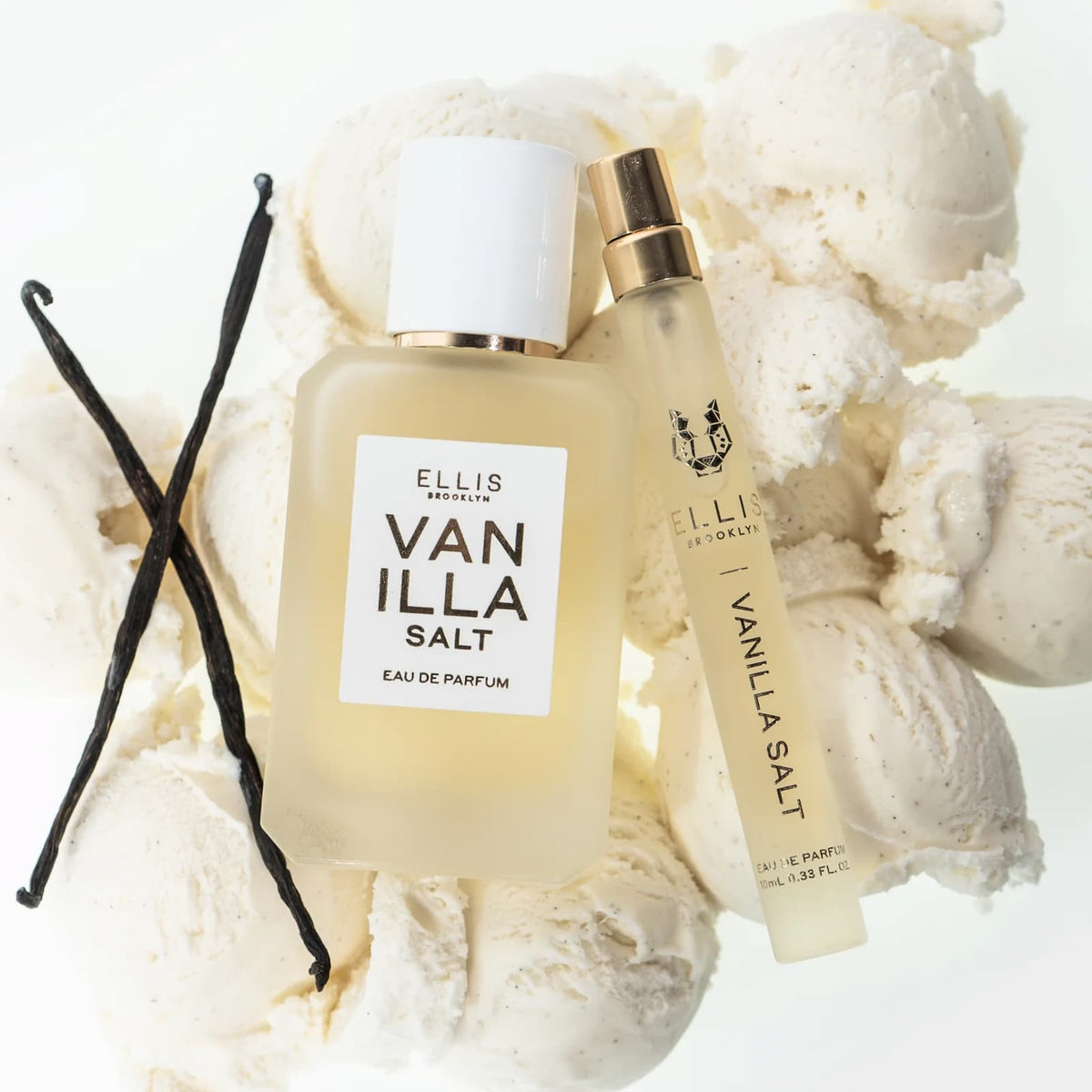 Two glass bottles of Ellis Brooklyn Vanilla Salt perfume sitting on scoops of vanilla ice cream, next to vanilla beans.