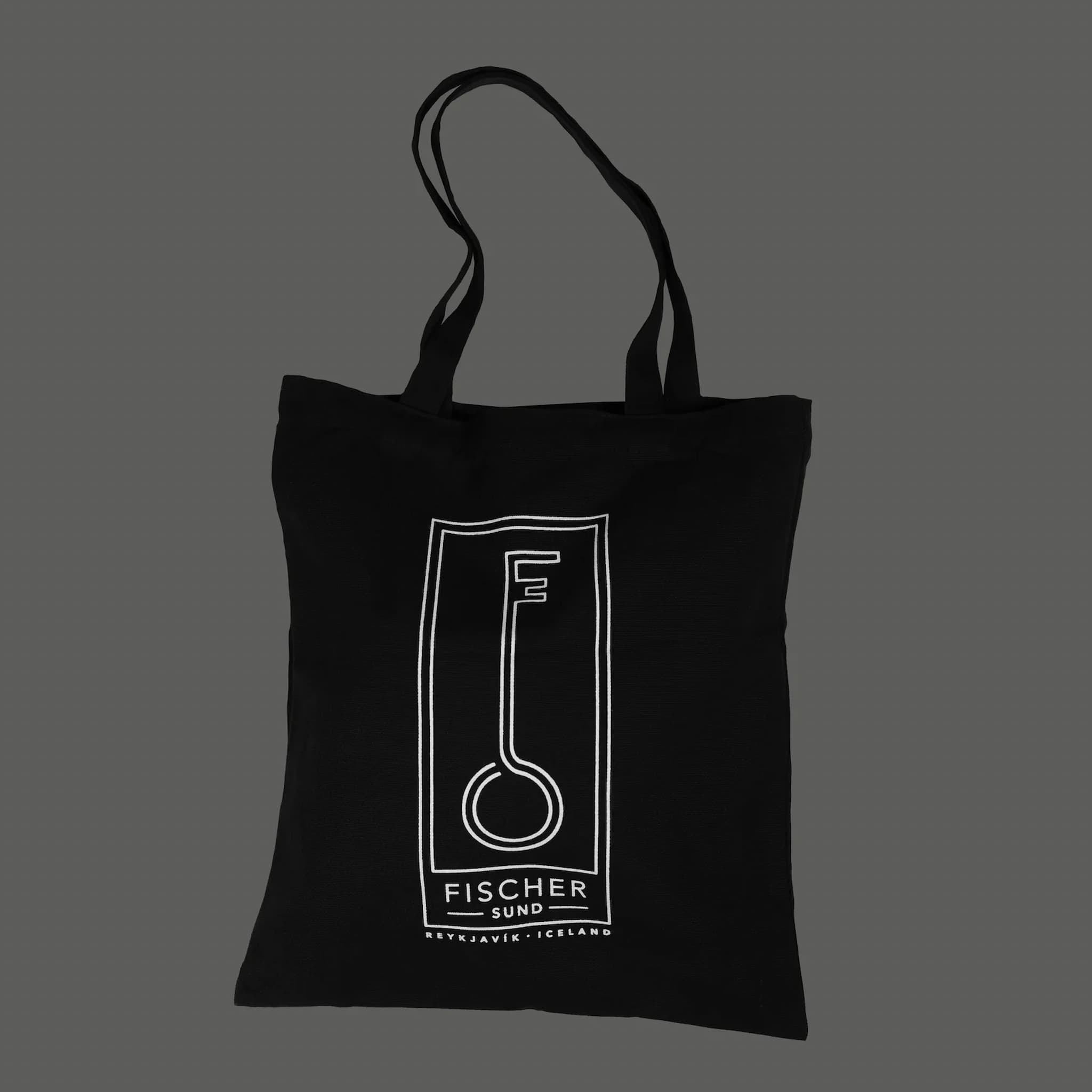 Black tote bag with white Fischersund logo and text on a dark gray background