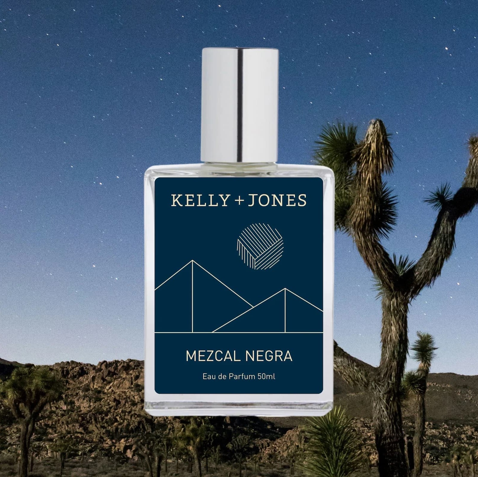 Perfume bottle labeled 'Kelly + Jones Mezcal Negra' with desert landscape and Joshua tree in the background