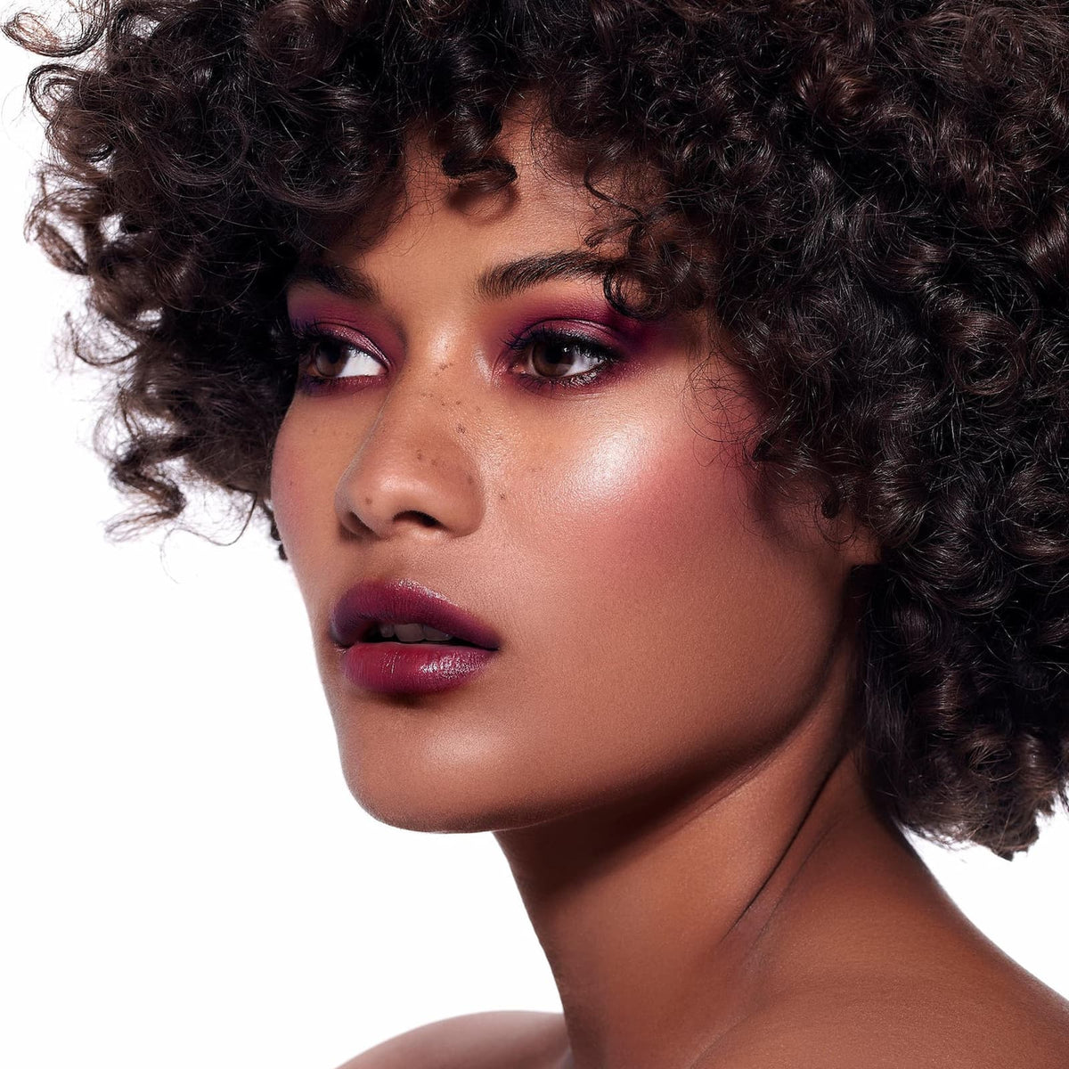 A model against a white background wears Rituel de Fille Inner Glow Pigment Balm in "Glasswing".