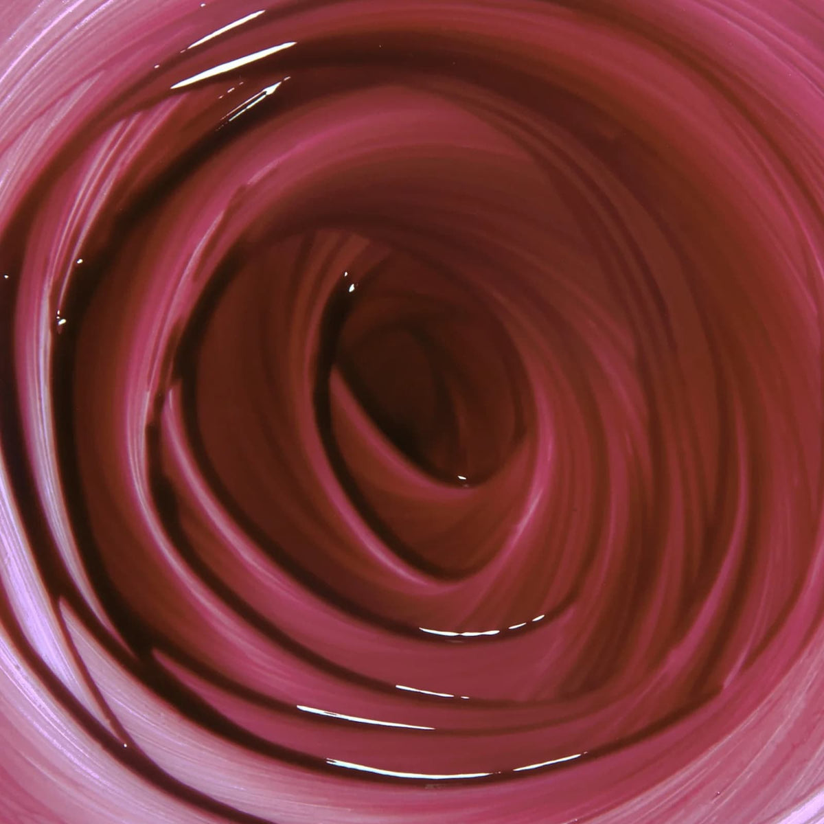 A close-up of a swirl of Rituel de Fille Inner Glow Pigment Balm in "Weeping Cherry".