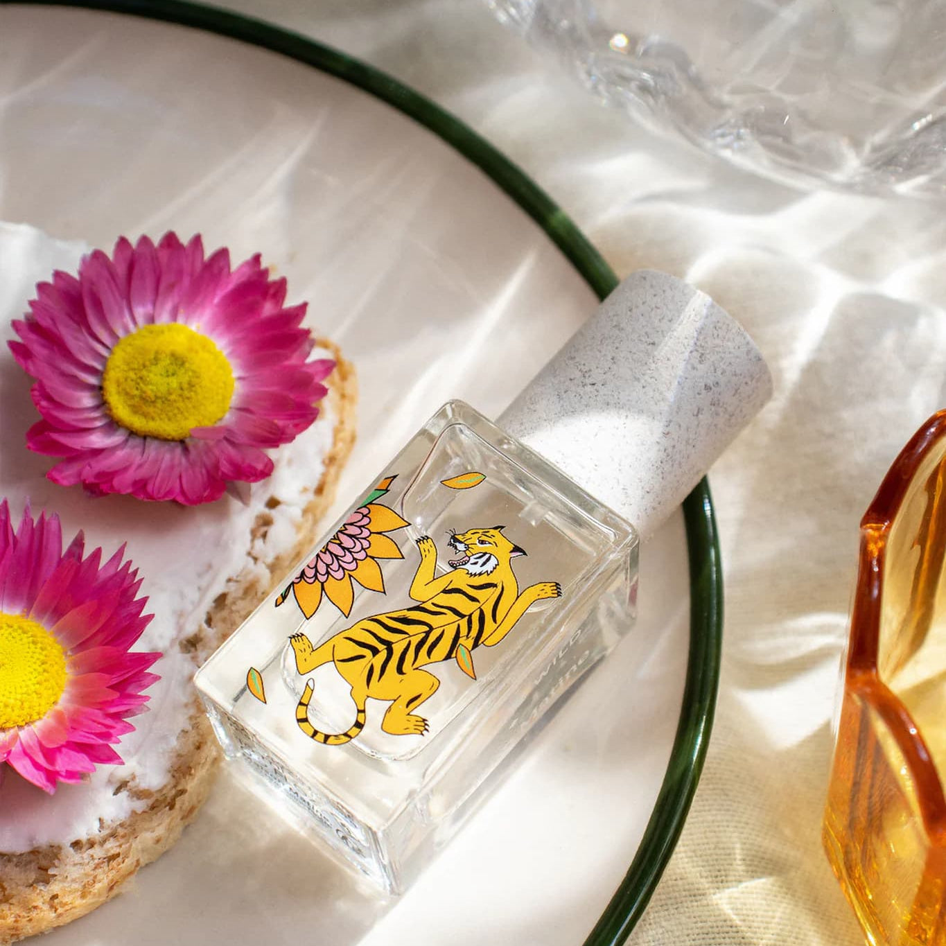 Small bottle with tiger design on a white background with pink flowers