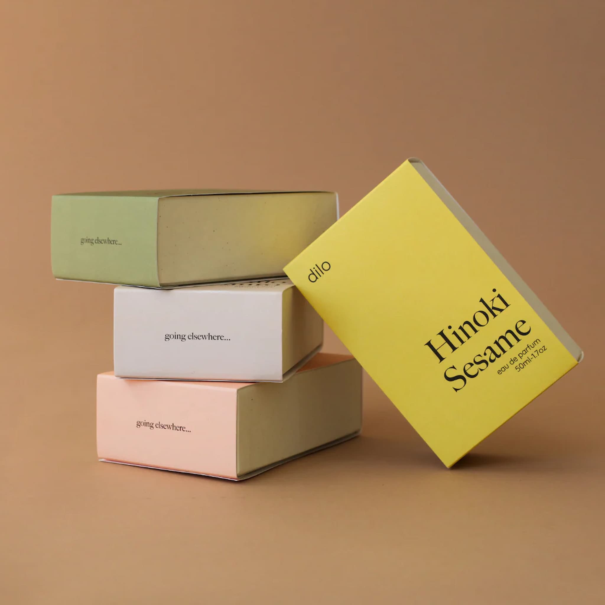 Stack of small boxes with 'Hinoki Sesame' packaging on a brown background