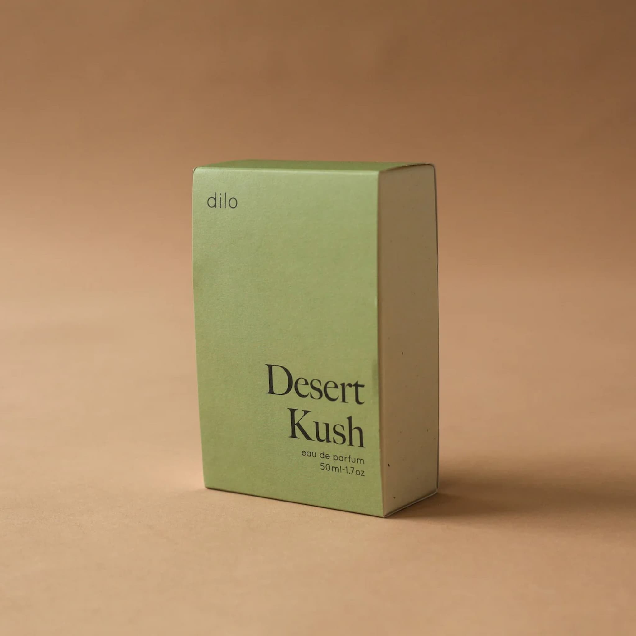 Green box of 'Desert Kush' perfume by 'dilo' on a brown background
