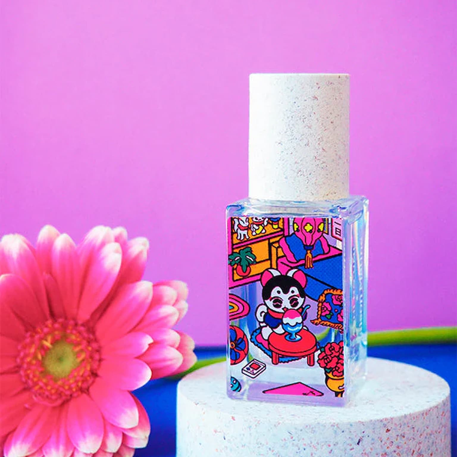 Small bottle with colorful label on a white stand against a rosy background with a pink flower.