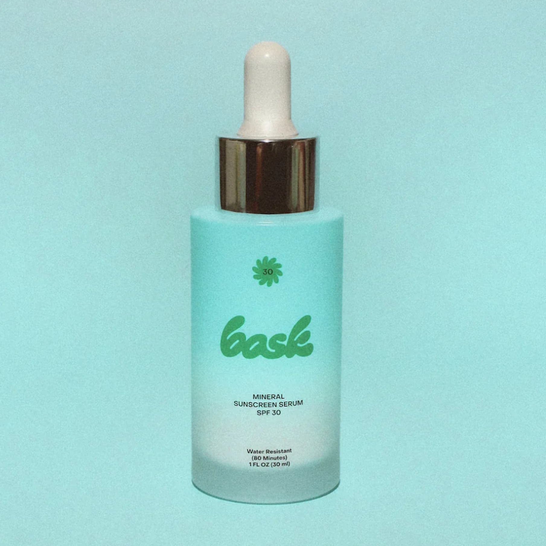Bask SPF 30 Mineral Sunscreen Serum bottle on a blue background.