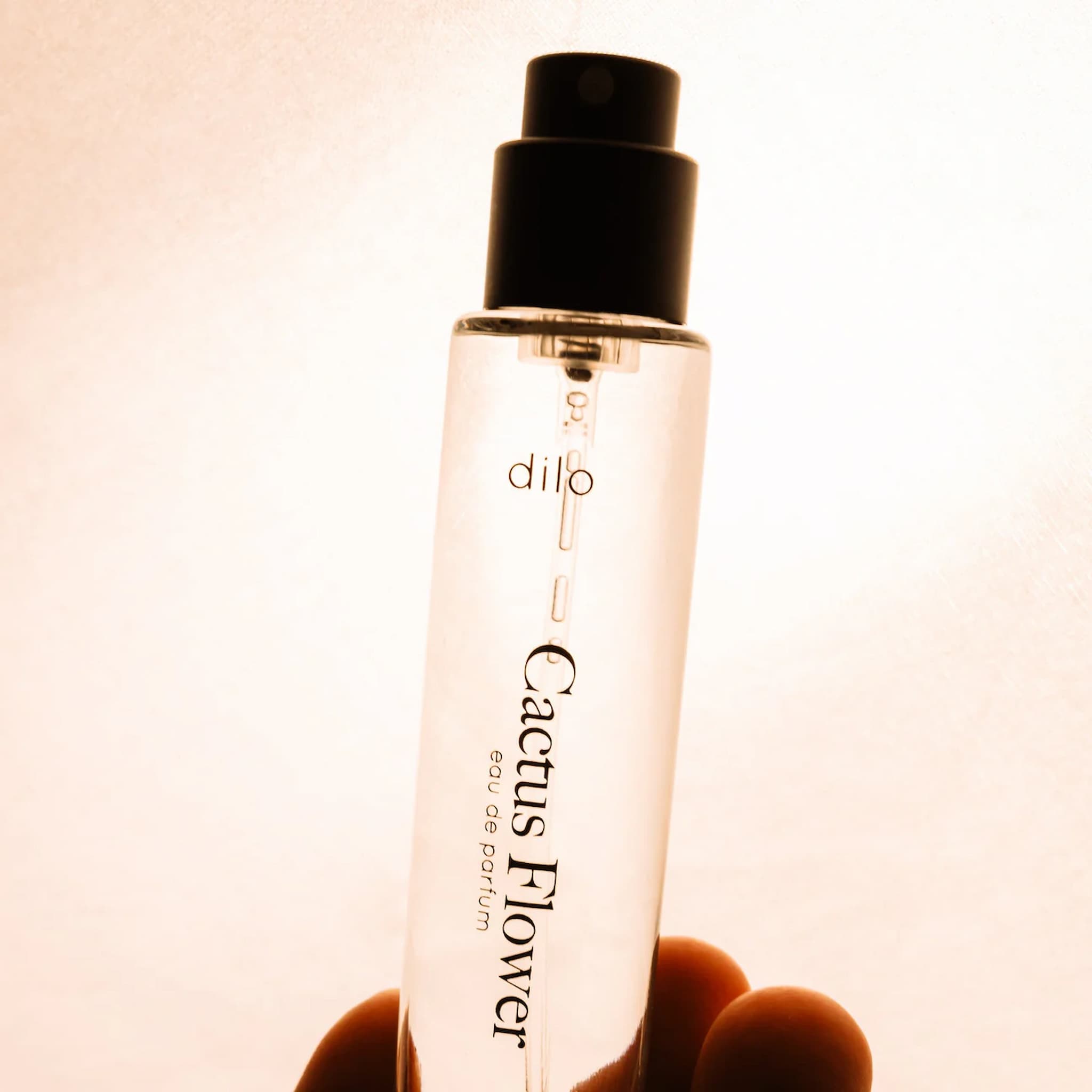Dilo Perfume bottle labeled 'Cactus Flower' held by a hand against a blurred background