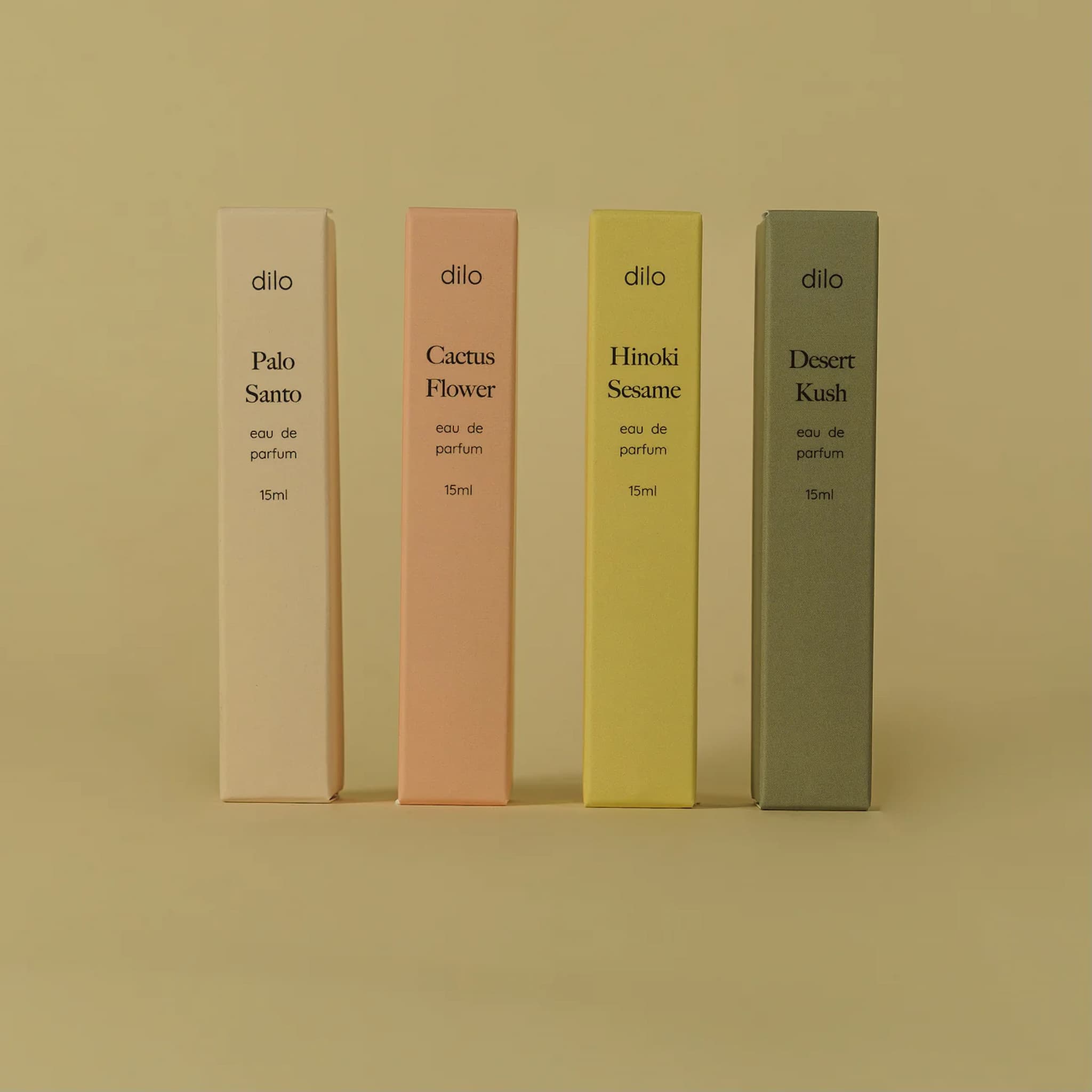 Four dilo perfume bottles in different colors on a beige background