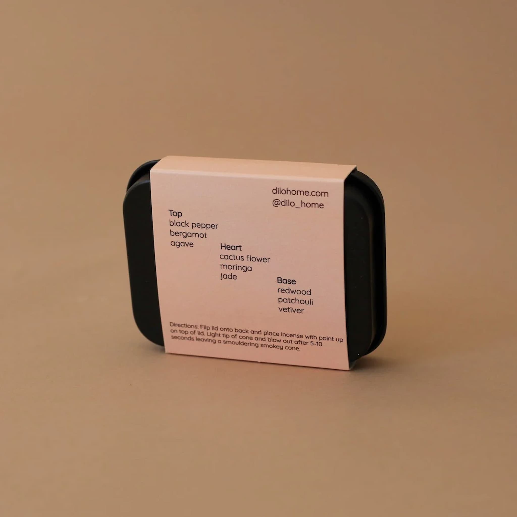 Black container with a pink label on a brown background