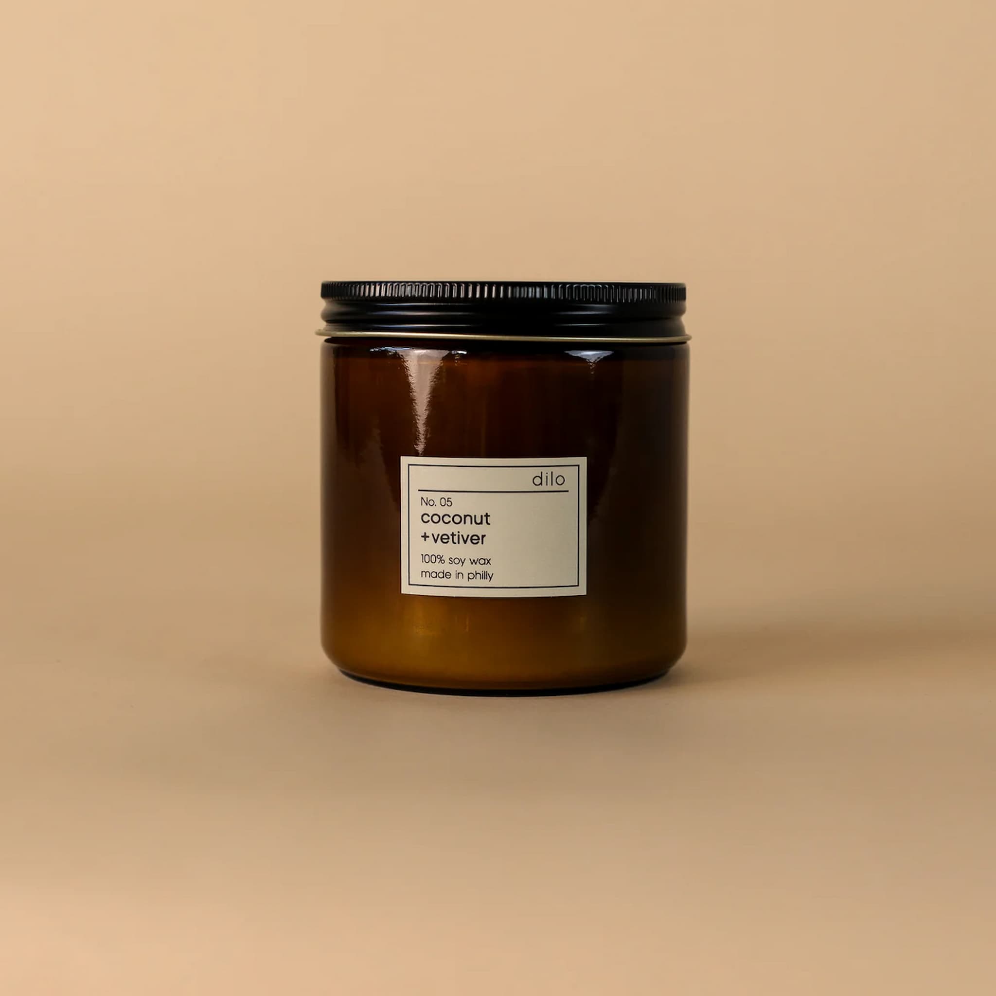 Brown candle jar with a label on a beige background
