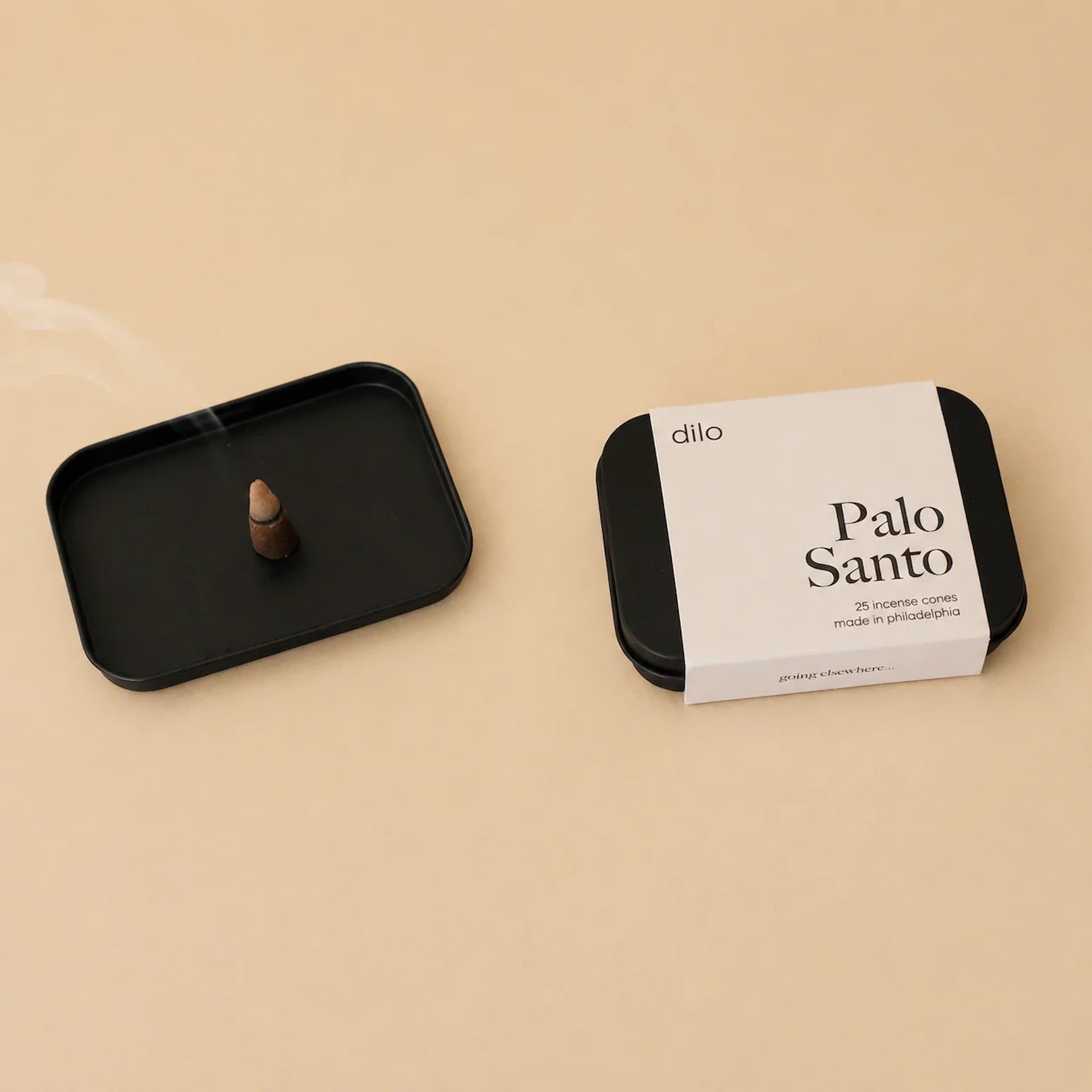 Black and cream packaging of dilo Palo Santo with a black tray on a beige background