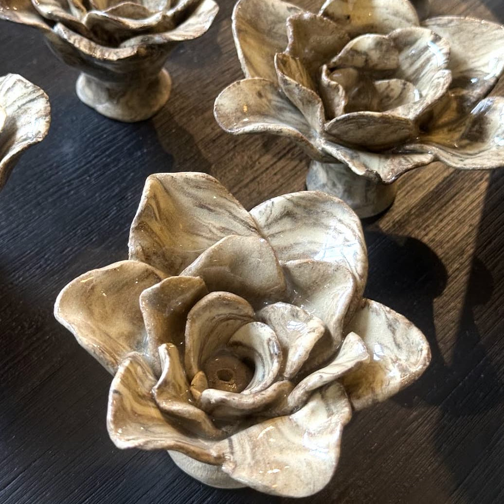 Nerikomi ceramic rose incense holders with a glossy, marbled neutral glaze, displayed on a dark wooden table.