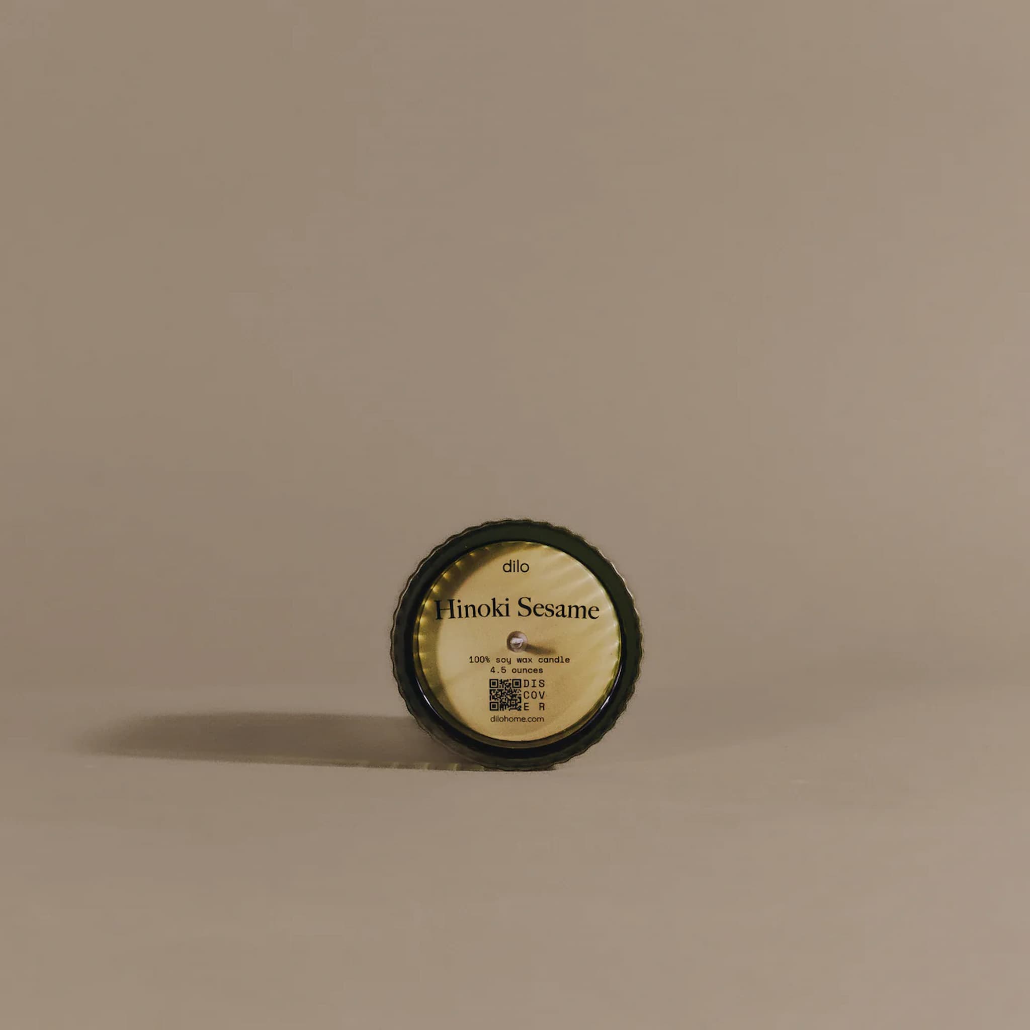 Round container labeled 'Hinoki Sesame' by dilo on a beige background