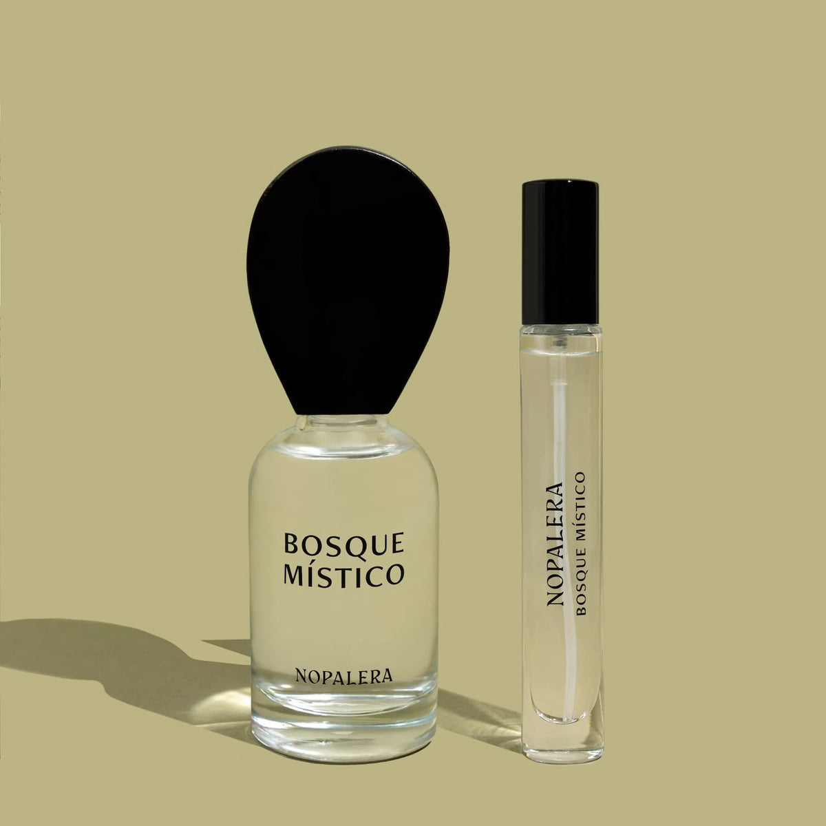 Two glass bottles of Nopalera "Basque Mistico" perfume, both the regular and travel size.