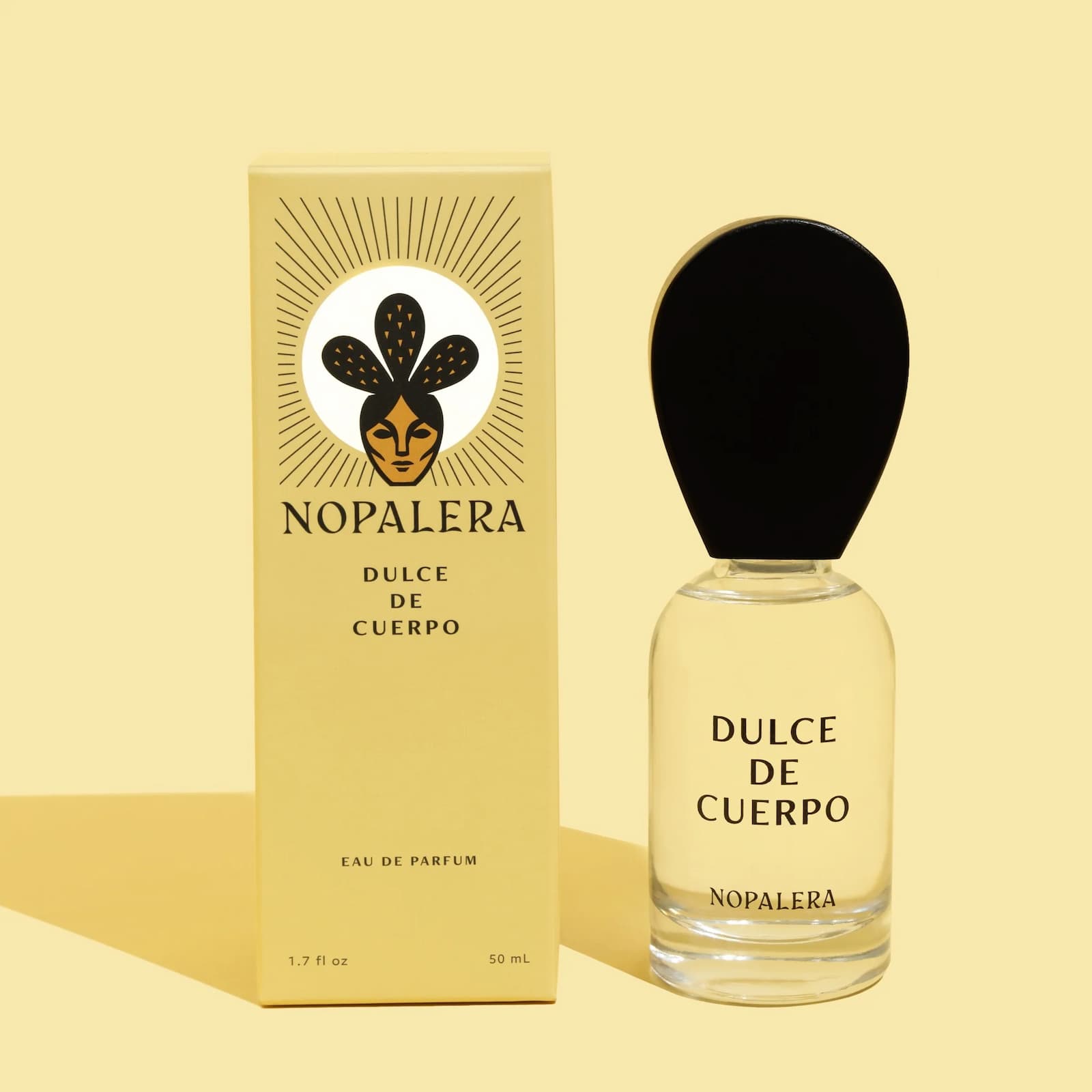 Yellow box and glass bottle of the full size Nopalera Dulce de Cuerpo perfume against a yellow background