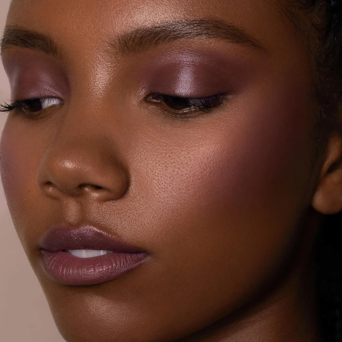 A close-up of a model wearing Rituel de Fille Inner Glow Pigment Balm in "Moth".