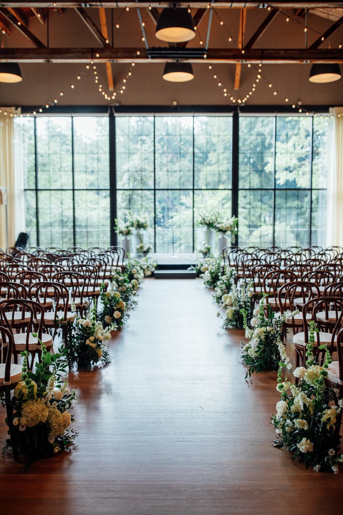 Ceremony space for a Roundhouse wedding featuring white and green flowers by Witch Hazel in Beacon, NY.