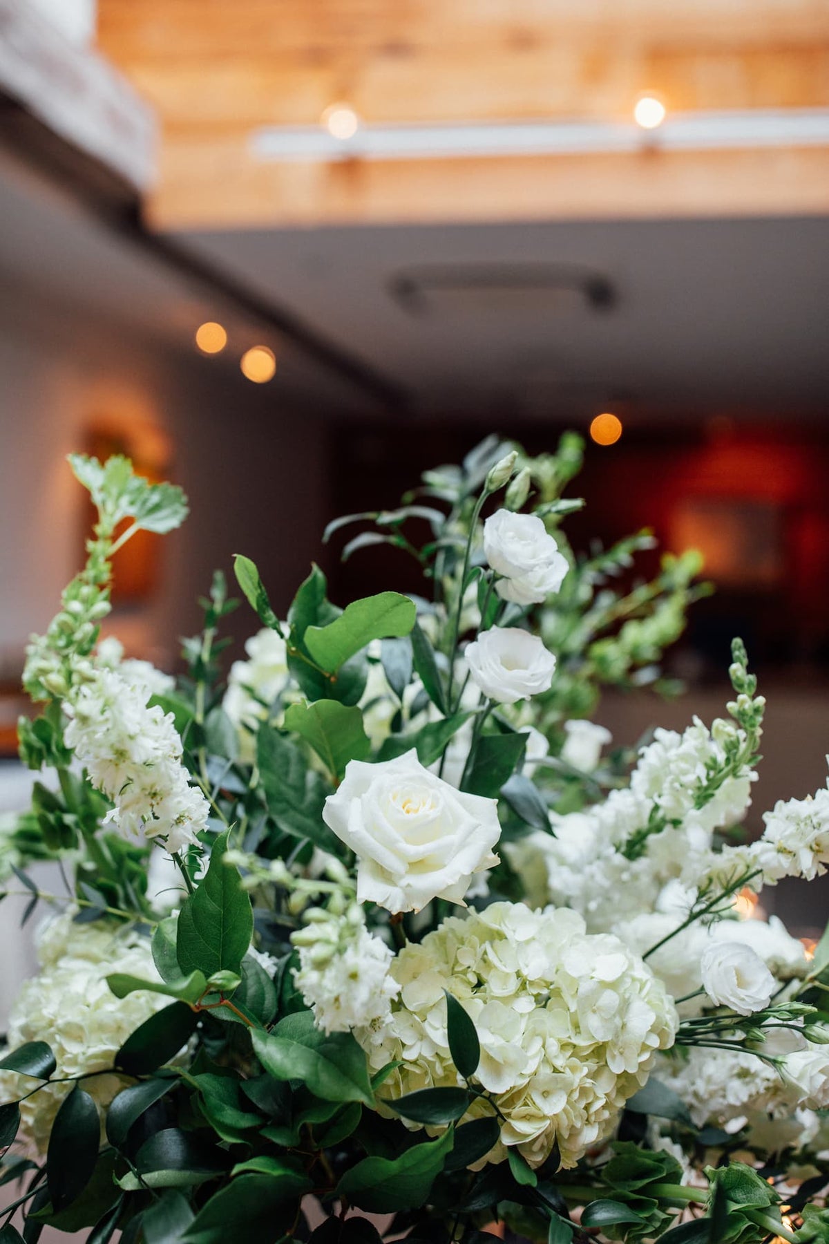 A close-up of Beacon, NY wedding flowers featuring white roses, green hydrangeas, and green foliage, photographed at the Roundhouse event space in Beacon, NY.